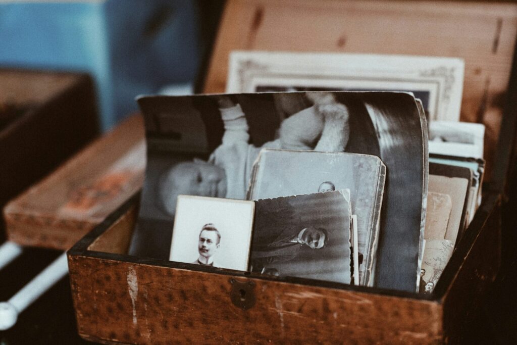 A wooden box filled with vintage black-and-white photographs, representing memories, history, and the lasting legacy of individuals—symbolic of the contributions made through whole body donation to medical science and education.